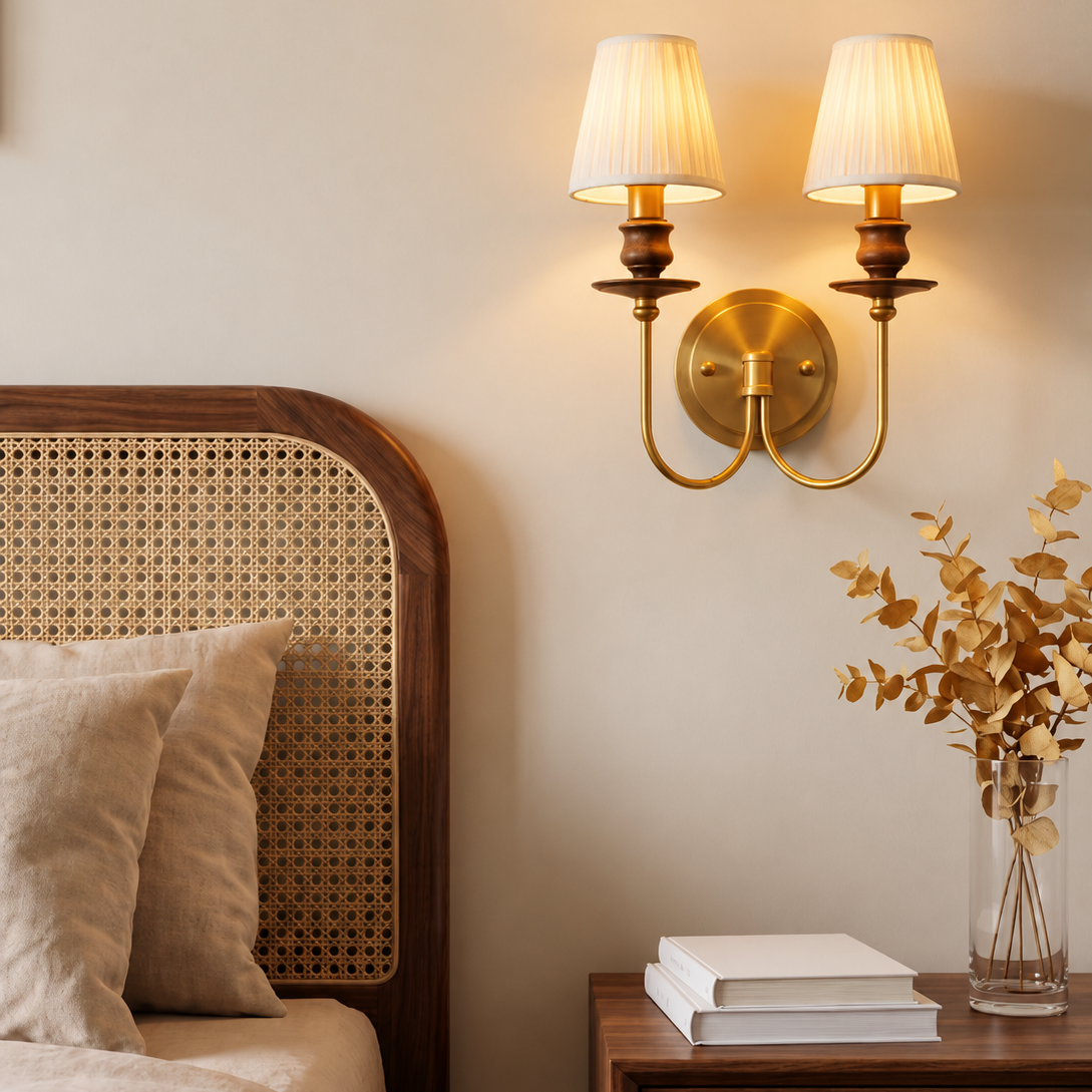 Two-light brass wall sconce with two pleated drum shades and curved arms