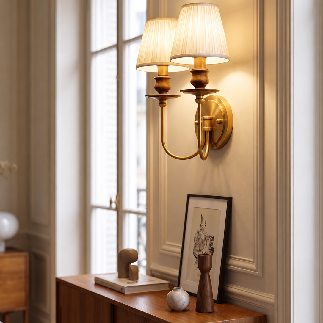 Two-light brass wall sconce with pleated shades and round wall mount