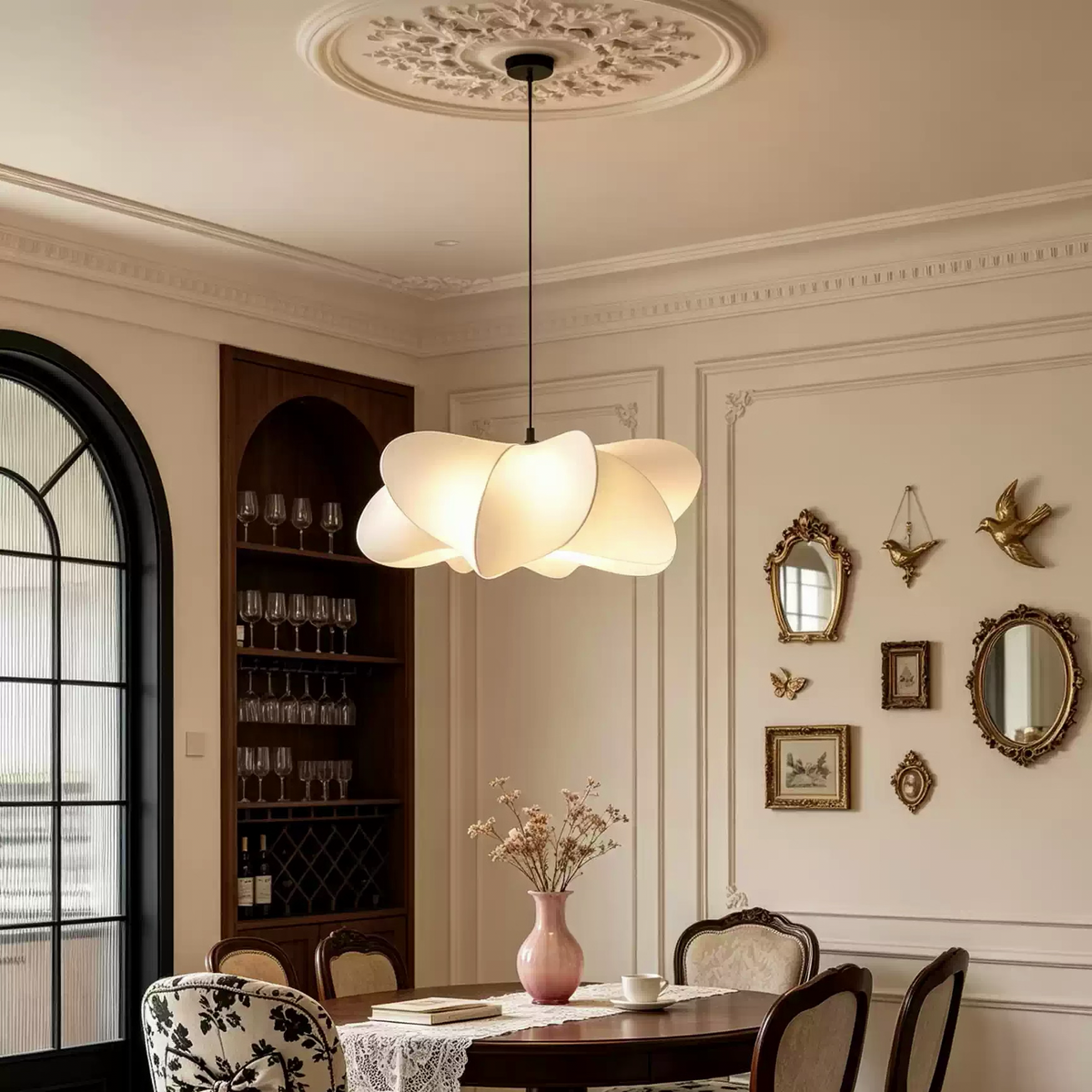Cream beige sculptural silk petal pendant light centered above dining table and flowers