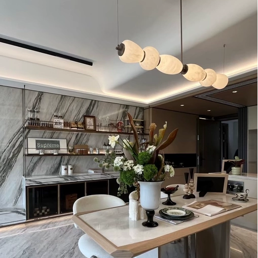 Sculptural linear chandelier with alabaster oval shades on a brass bar
