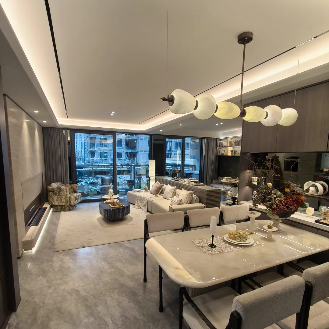 Linear gold chandelier with alabaster disc shades suspended above living and dining area