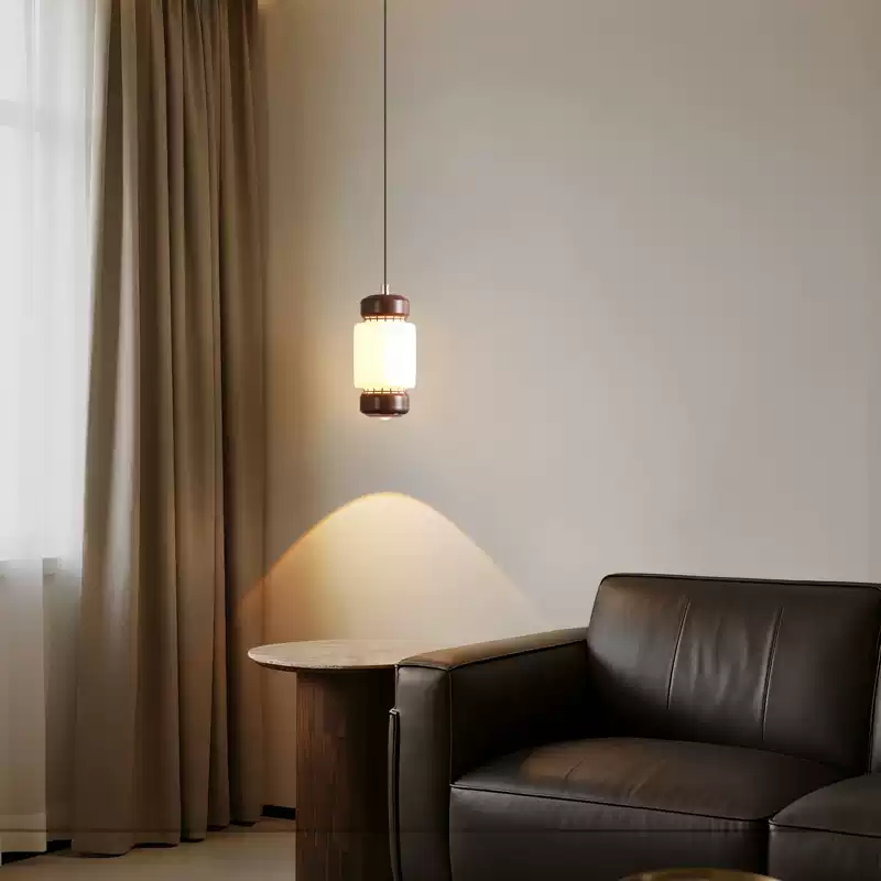 Small frosted glass cylinder pendant light with walnut accents and black ceiling mount