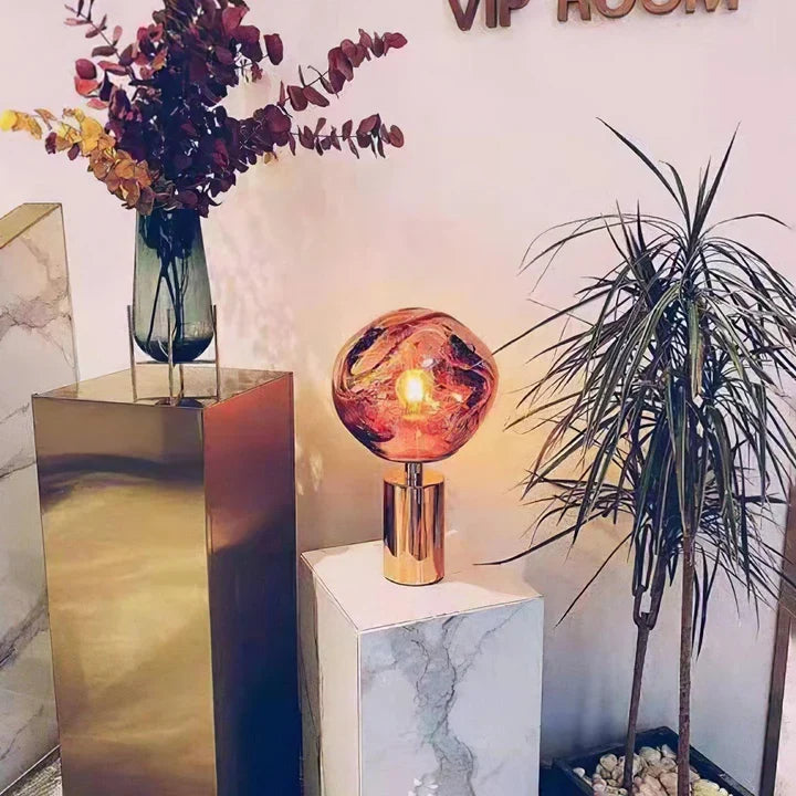 Copper table lamp with multicolor amber glass globe shade and glowing bulb