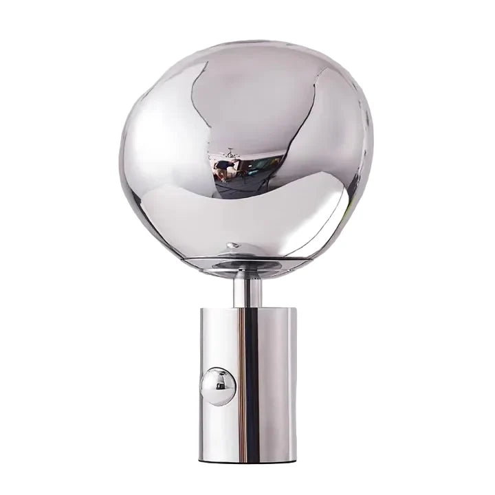 Chrome table lamp with clear glass globe shade and glowing bulb