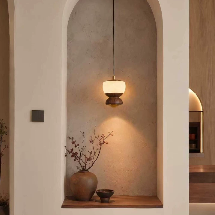 Walnut mini pendant light with frosted glass shade in an arched niche