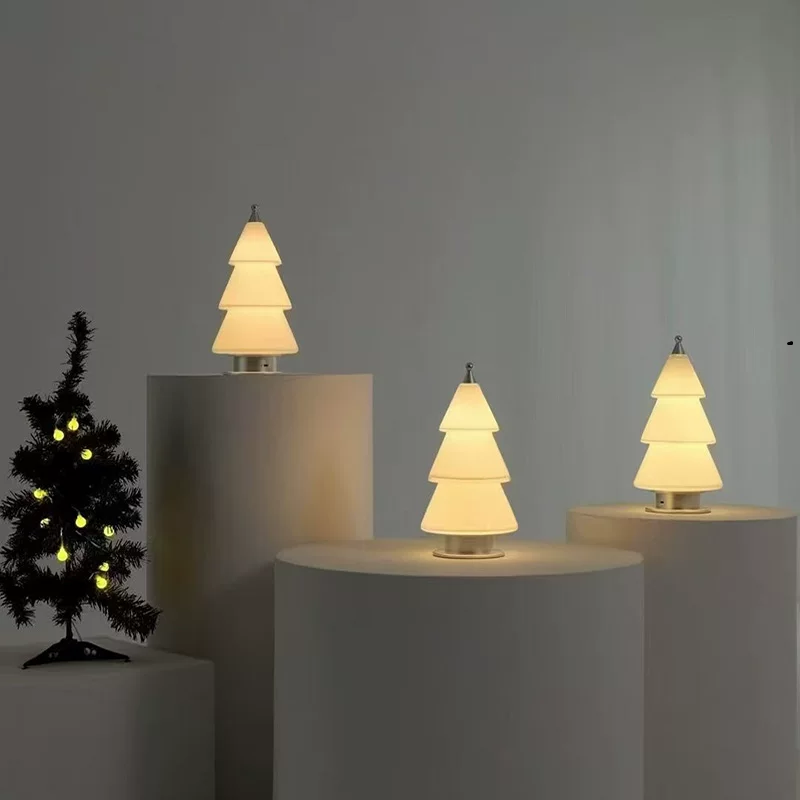 Warm-lit frosted glass tree table lamp with tiered cone shades and metal stand.