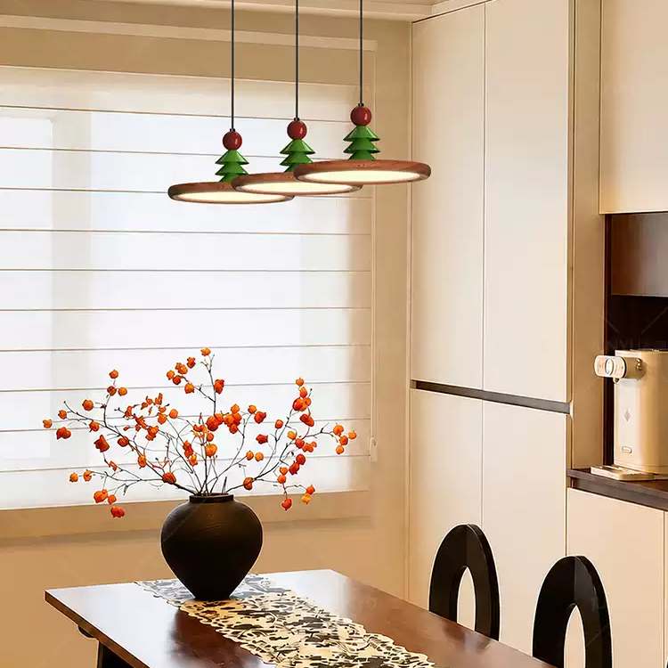 Three hanging disc pendant lights with wood rings, green pine ornaments and red beads