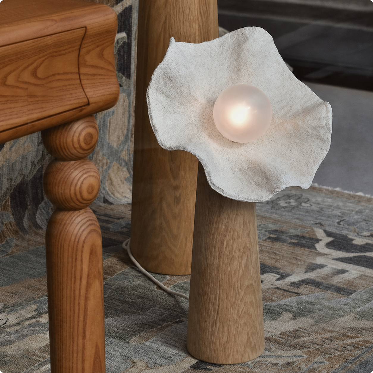 Mushroom floor lamp with textured light-gray shade and glowing bulb on wooden stand