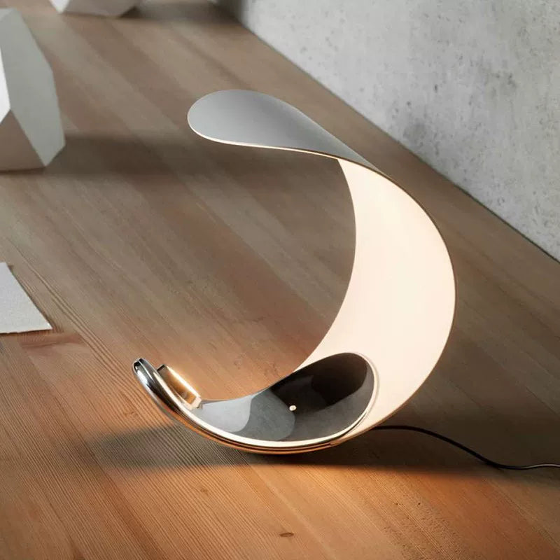 Crescent moon table lamp with white curved shade and chrome cradle base