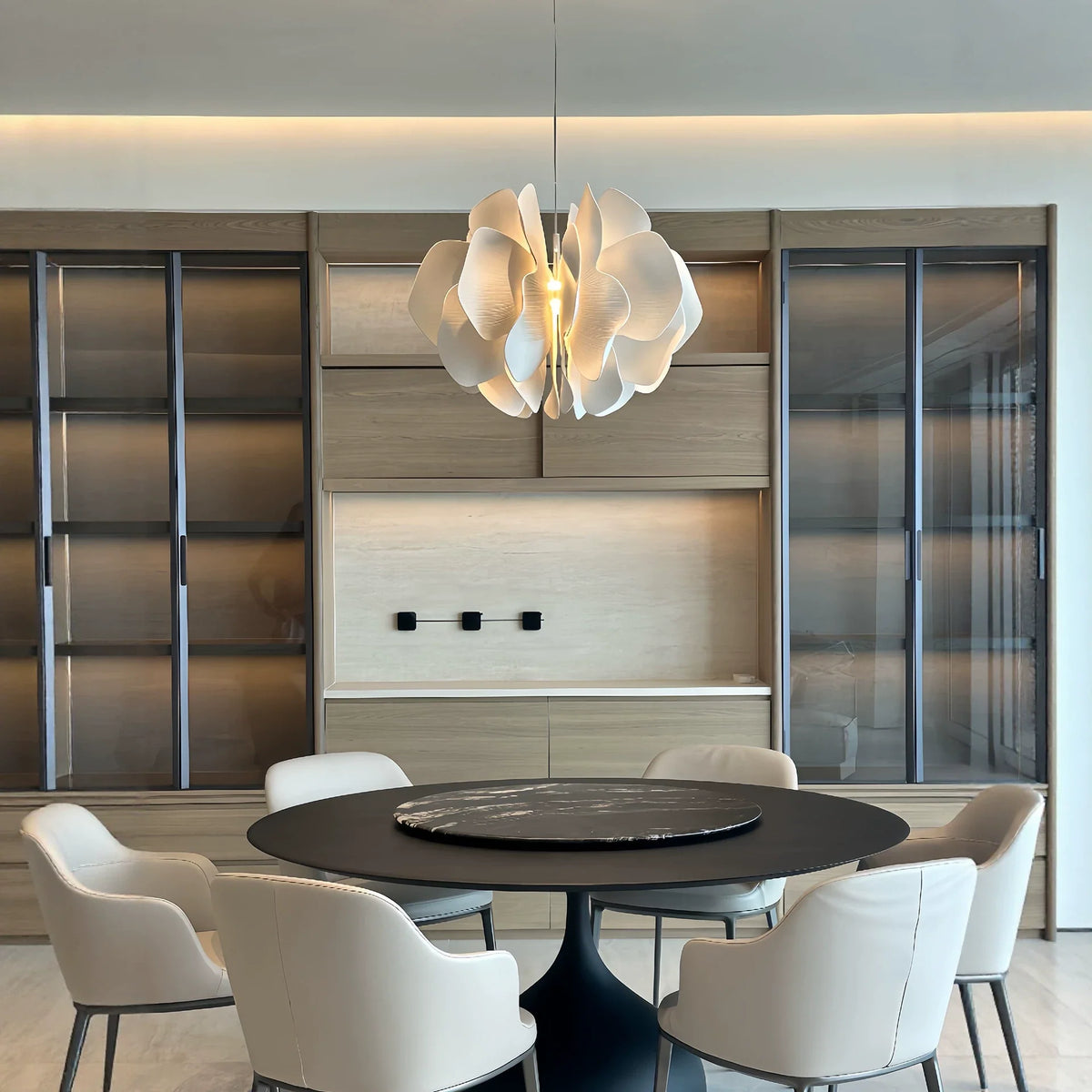 Ceramic petal chandelier with glowing white petal shades suspended by a cord