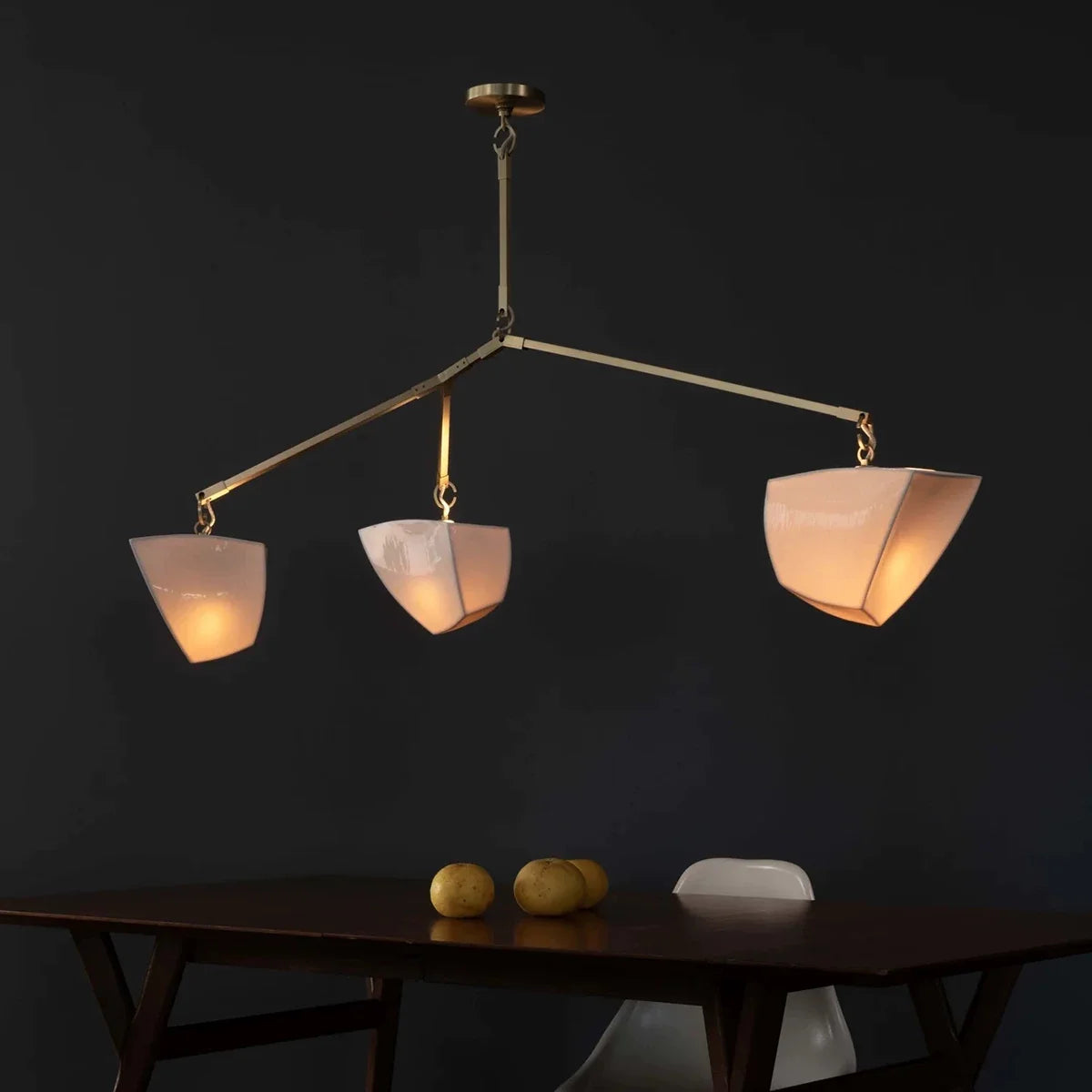 Brass branching chandelier with five off-white cone shades on curved branching arms