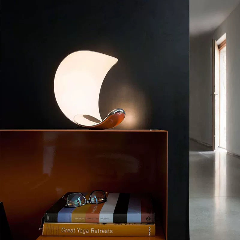 Crescent moon table lamp with glowing white shade and chrome metal base