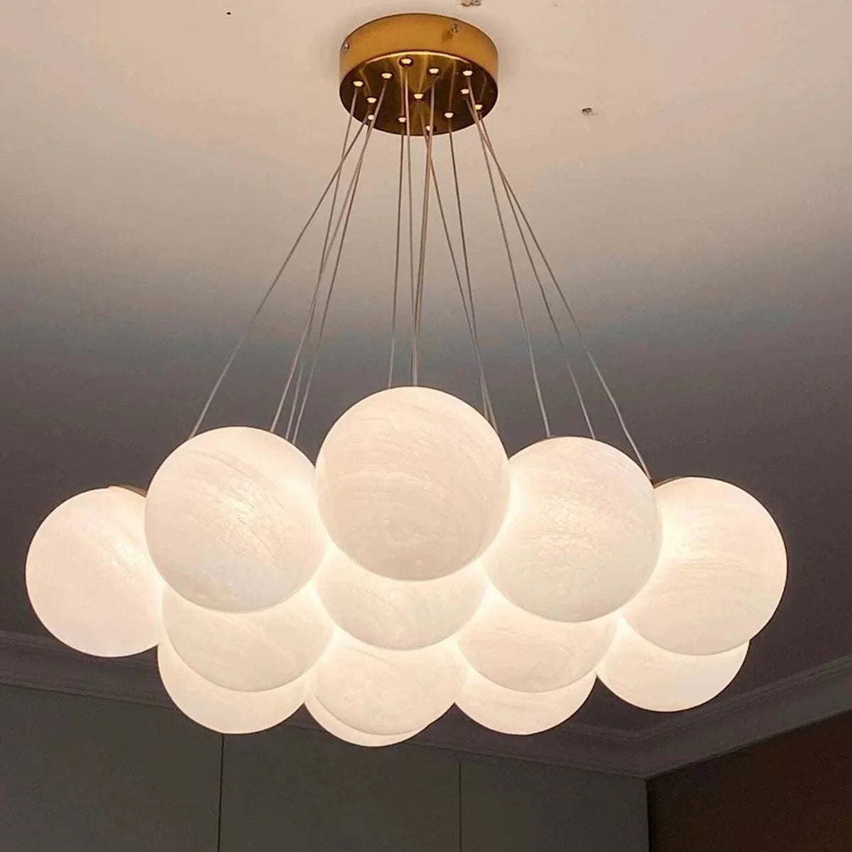 Multi-arm globe chandelier featuring a gold ceiling plate and multiple frosted globe lights