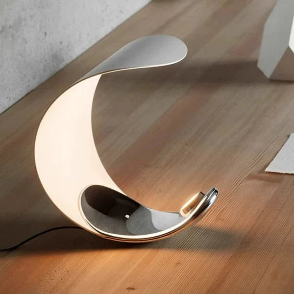 Crescent moon table lamp with white curved shade and chrome cradle base