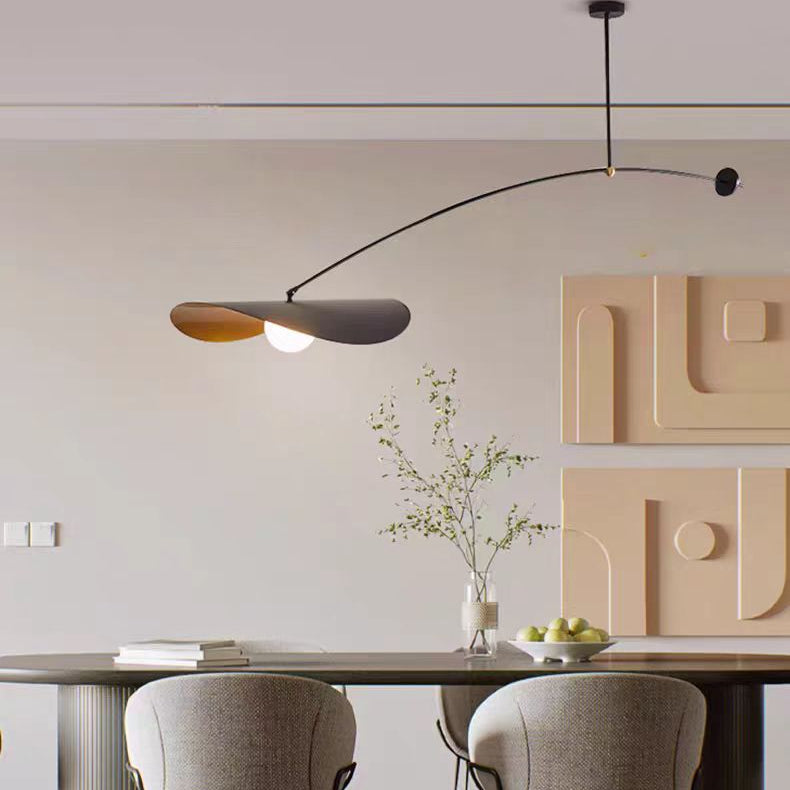 Single-arm pendant light with black curved arm and gold inner shade hanging from ceiling