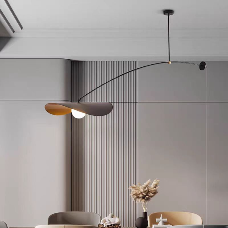 Single-arm pendant light with black arm, white bulb, and gold-tinted inner shade
