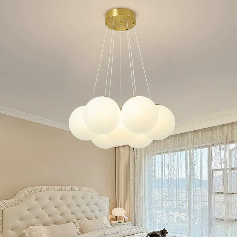 Multi-arm globe chandelier with gold ceiling mount and seven frosted spherical shades