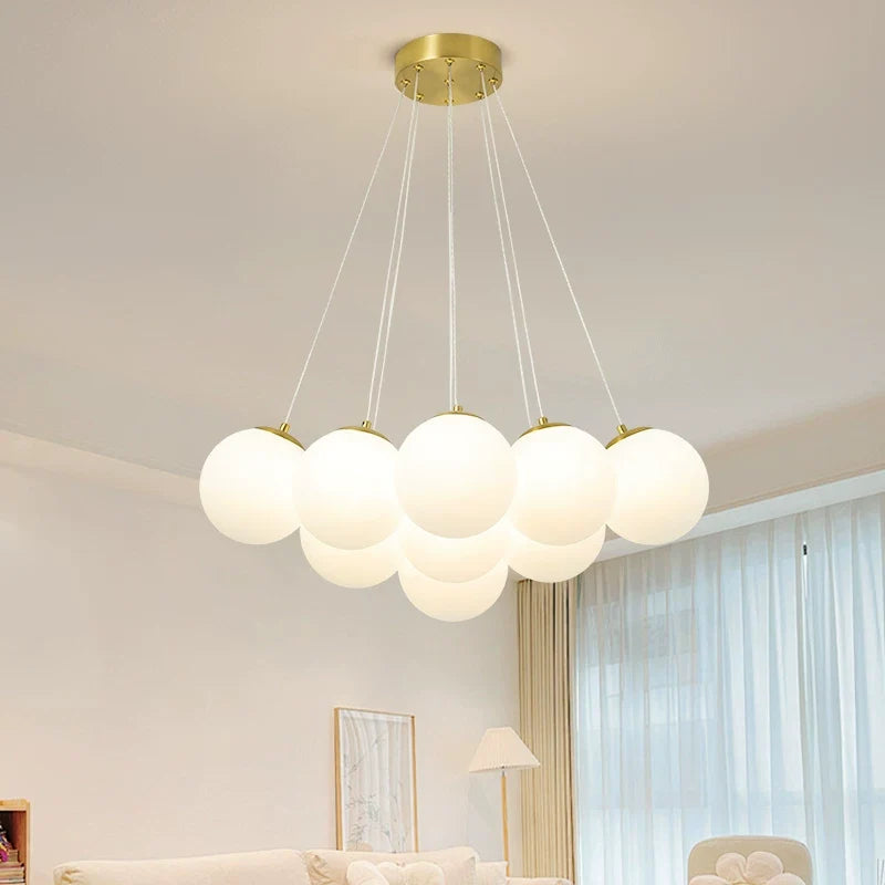 Multi-arm globe chandelier with gold round canopy and evenly spaced frosted globe shades