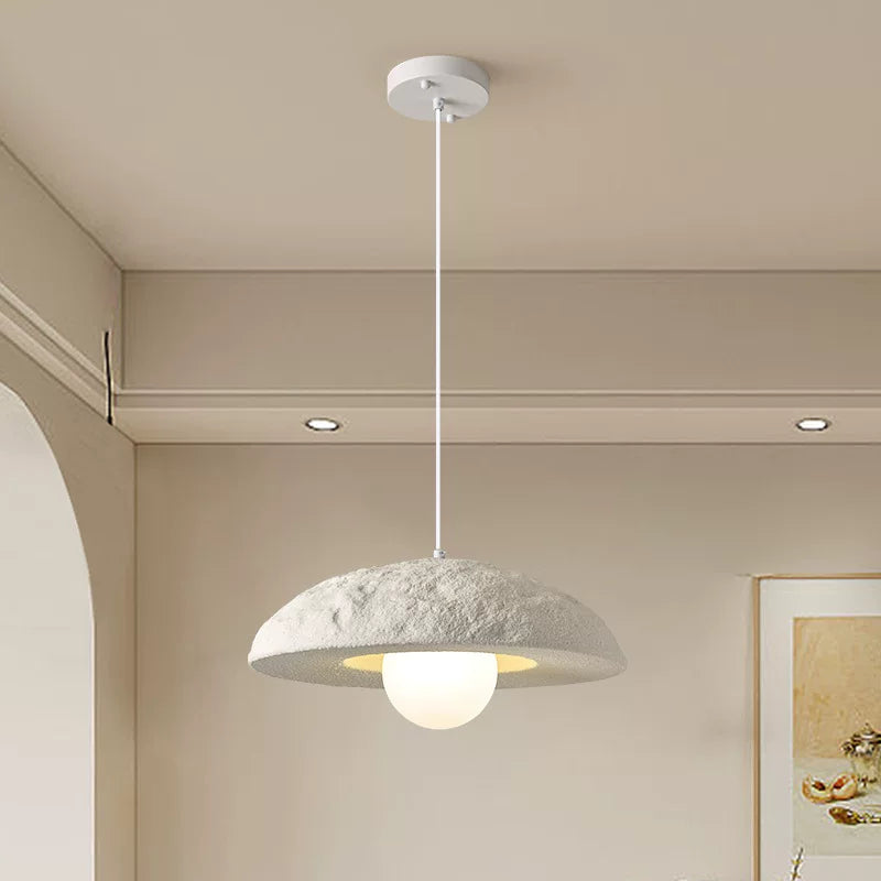 Ivory dome pendant light with textured dome shade and lit bulb under ceiling canopy