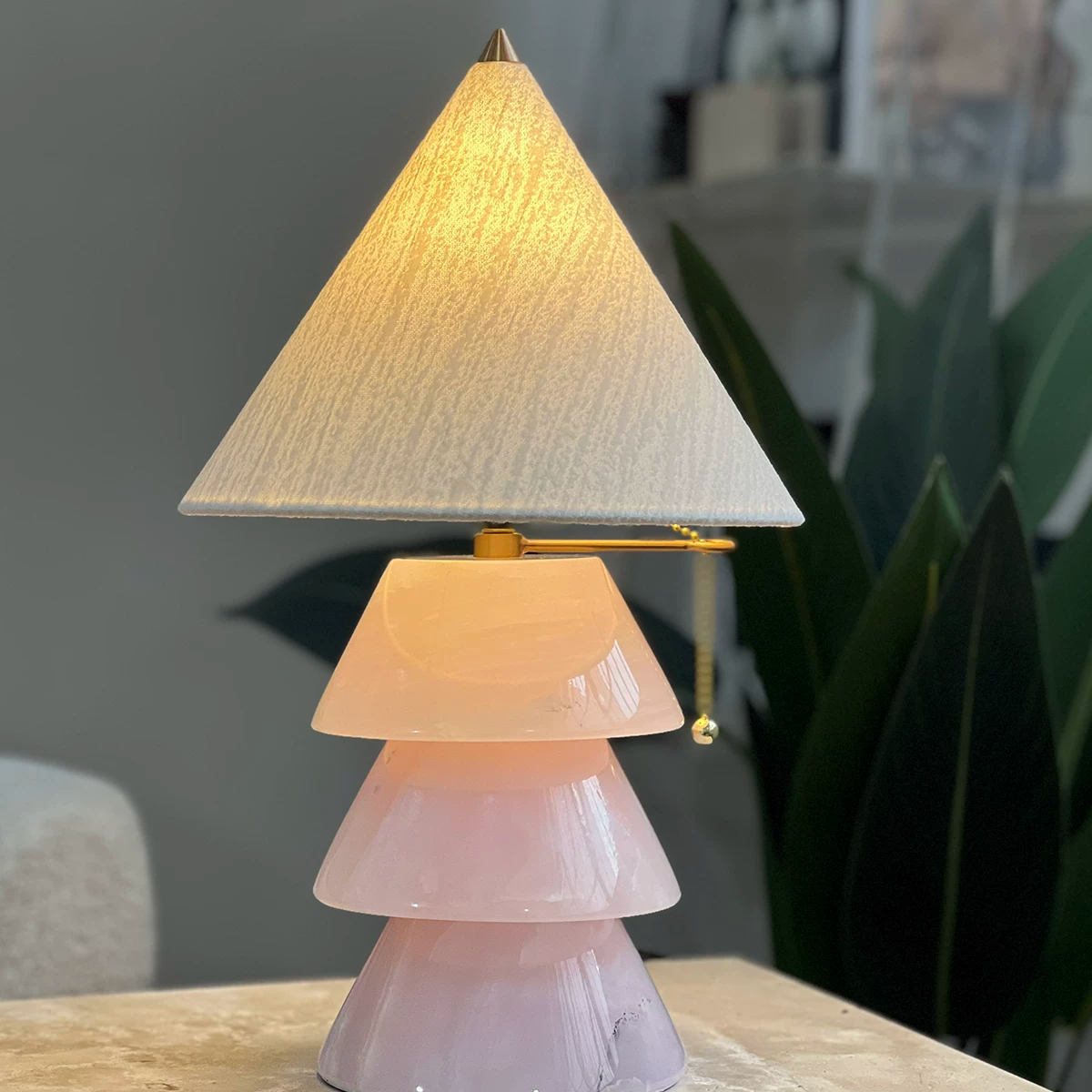 Carved jade-style tree table lamp with stacked conical shades and brass pull chain.