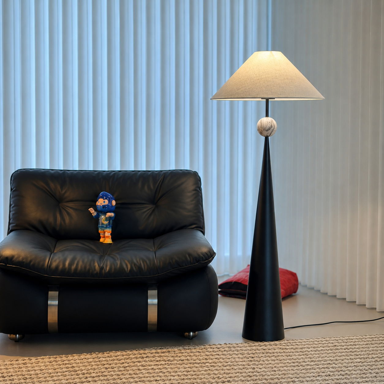 Black floor lamp with beige linen shade and round finial on slender column.