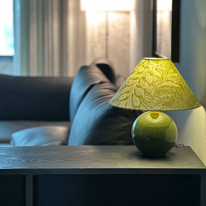 Sylva botanical ceramic table lamp on table with green base and yellow leafy shade