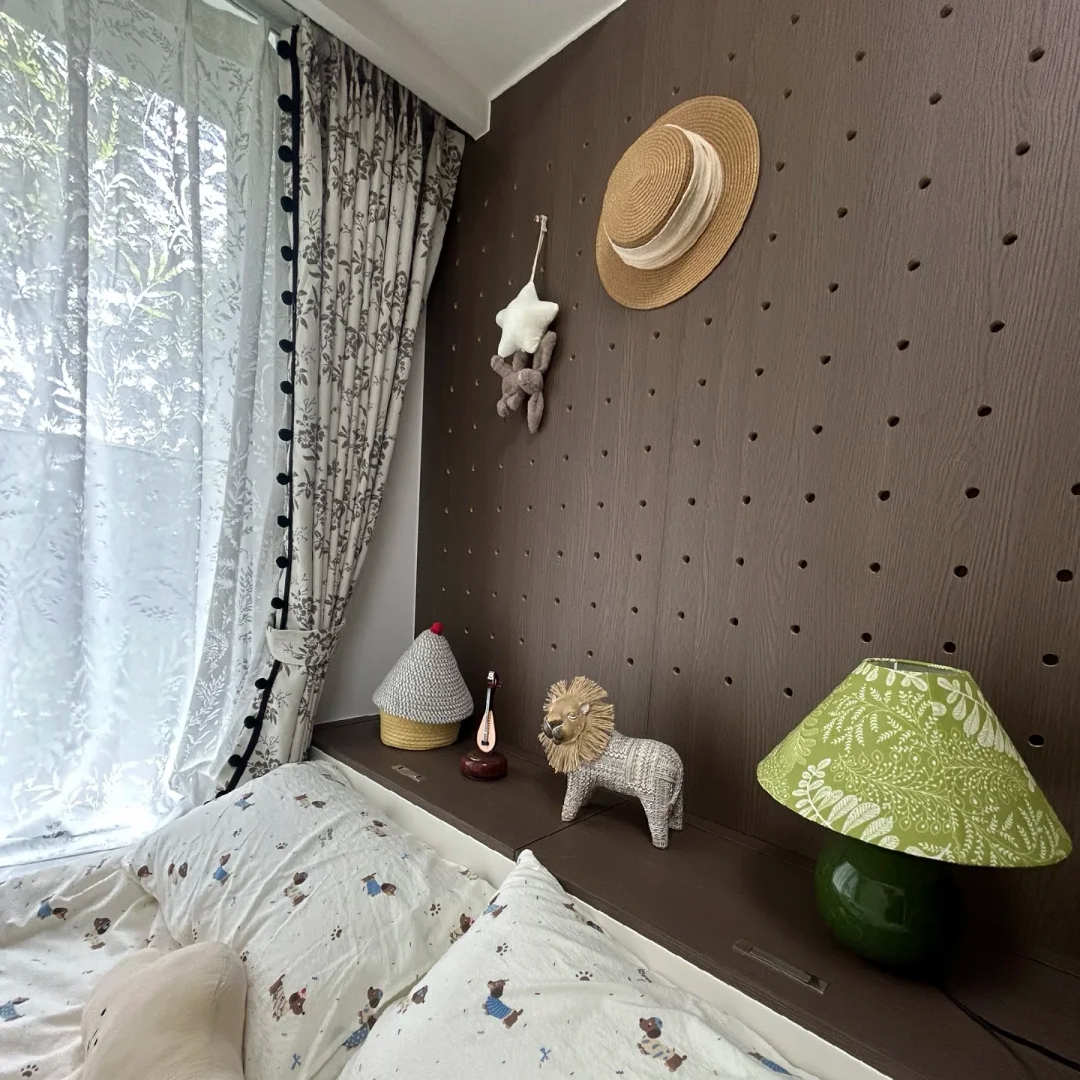 Green ceramic table lamp with botanical cone shade, displayed near bed on wall