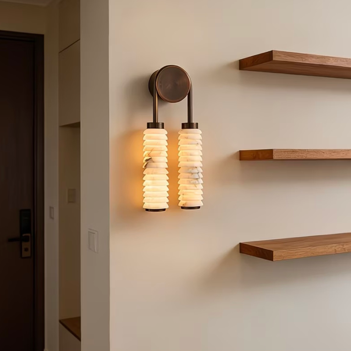 Tiered alabaster wall sconce with two stacked alabaster shades and bronze round mounting plate