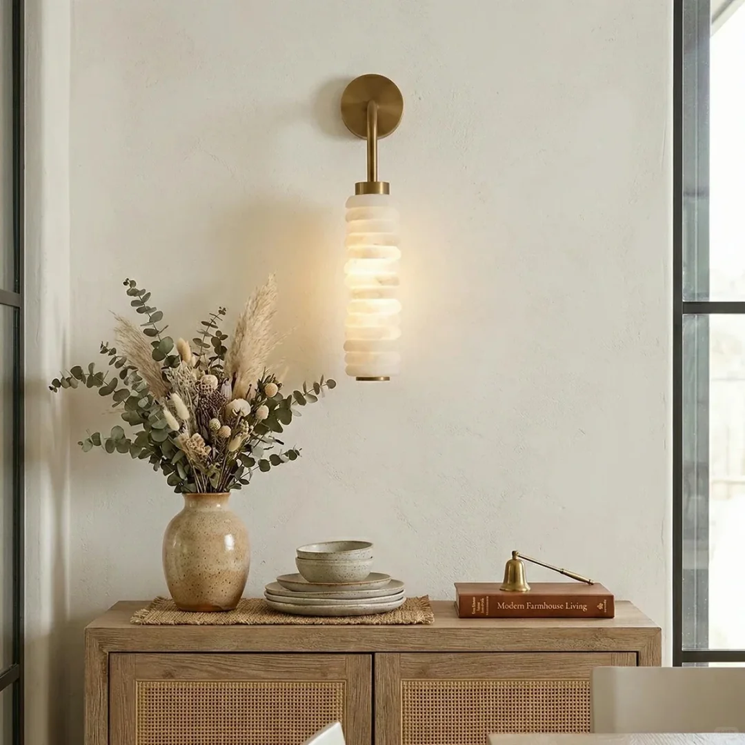 Tiered alabaster wall sconce with stacked cylindrical shade and round brass backplate