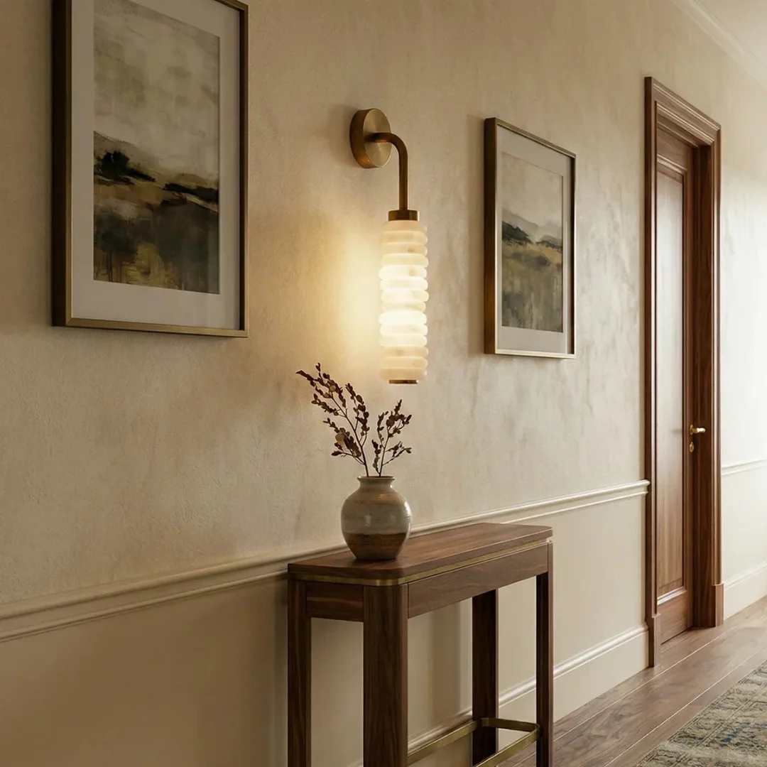 Tiered alabaster wall sconce with stacked cylindrical shade and curved brass wall bracket