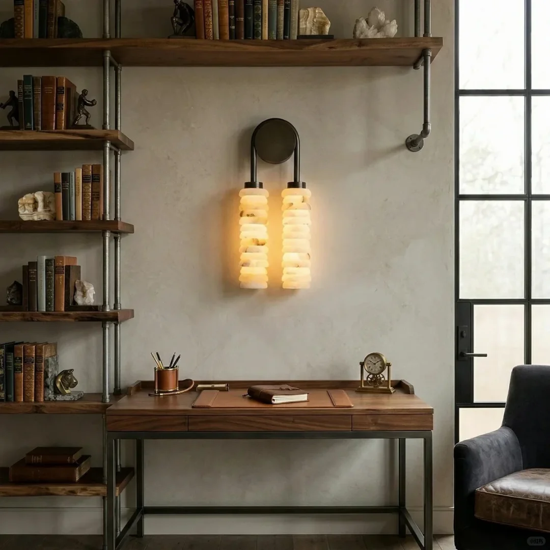 Tiered alabaster wall sconce pair with two stacked cylindrical shades and round metal backplates