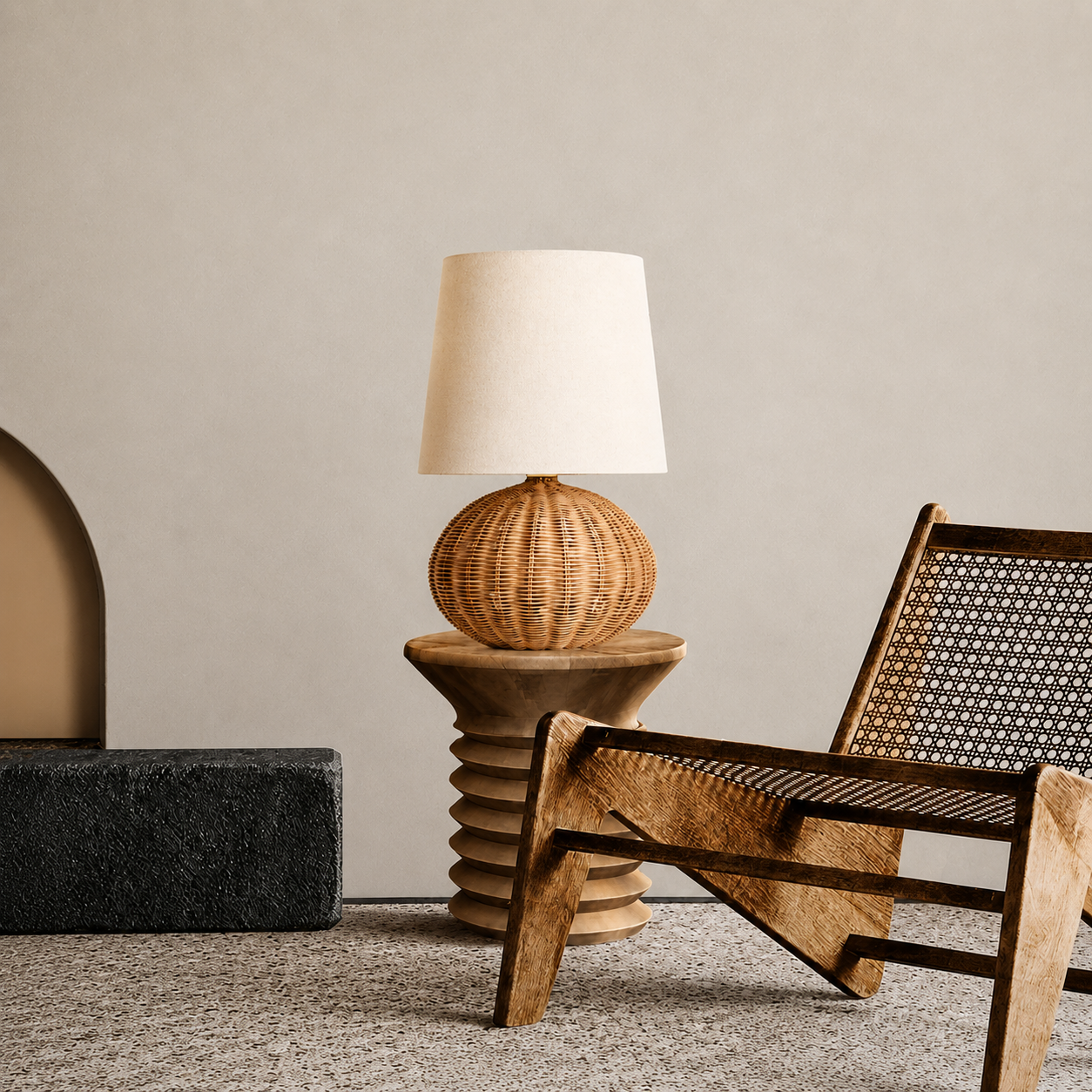 Rattan table lamp with beige drum shade and woven globe-shaped base.