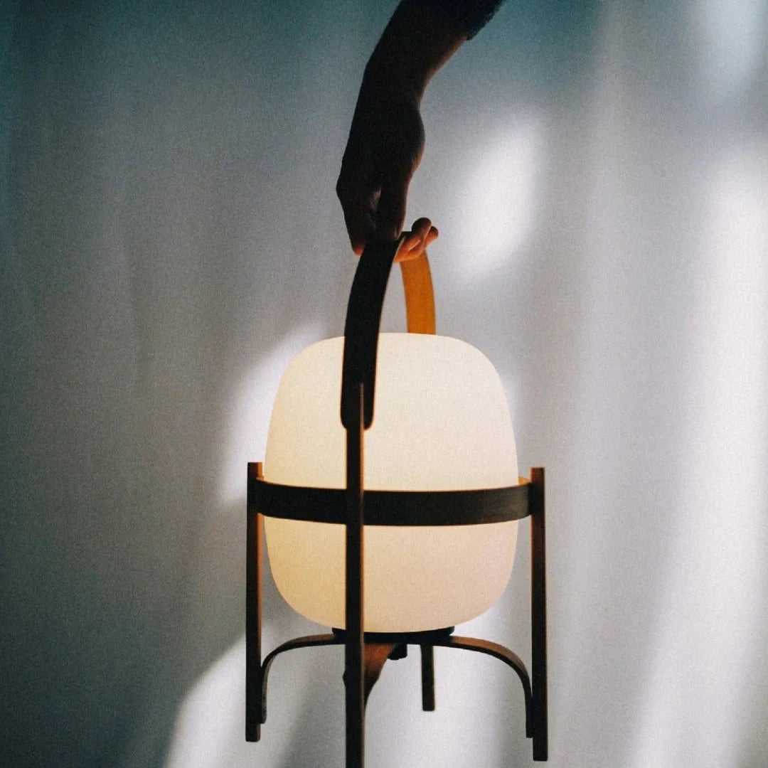 Hand-held lamp operation with warm-lit frosted globe and arched black frame