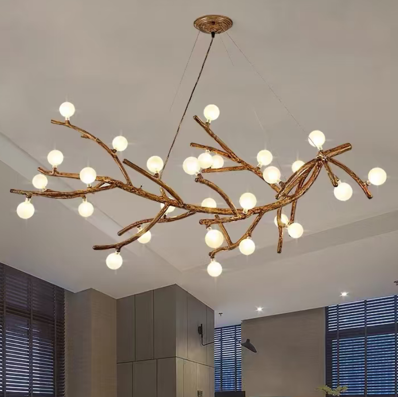 Gold branch chandelier with many round globe bulbs hanging in a ceiling room.