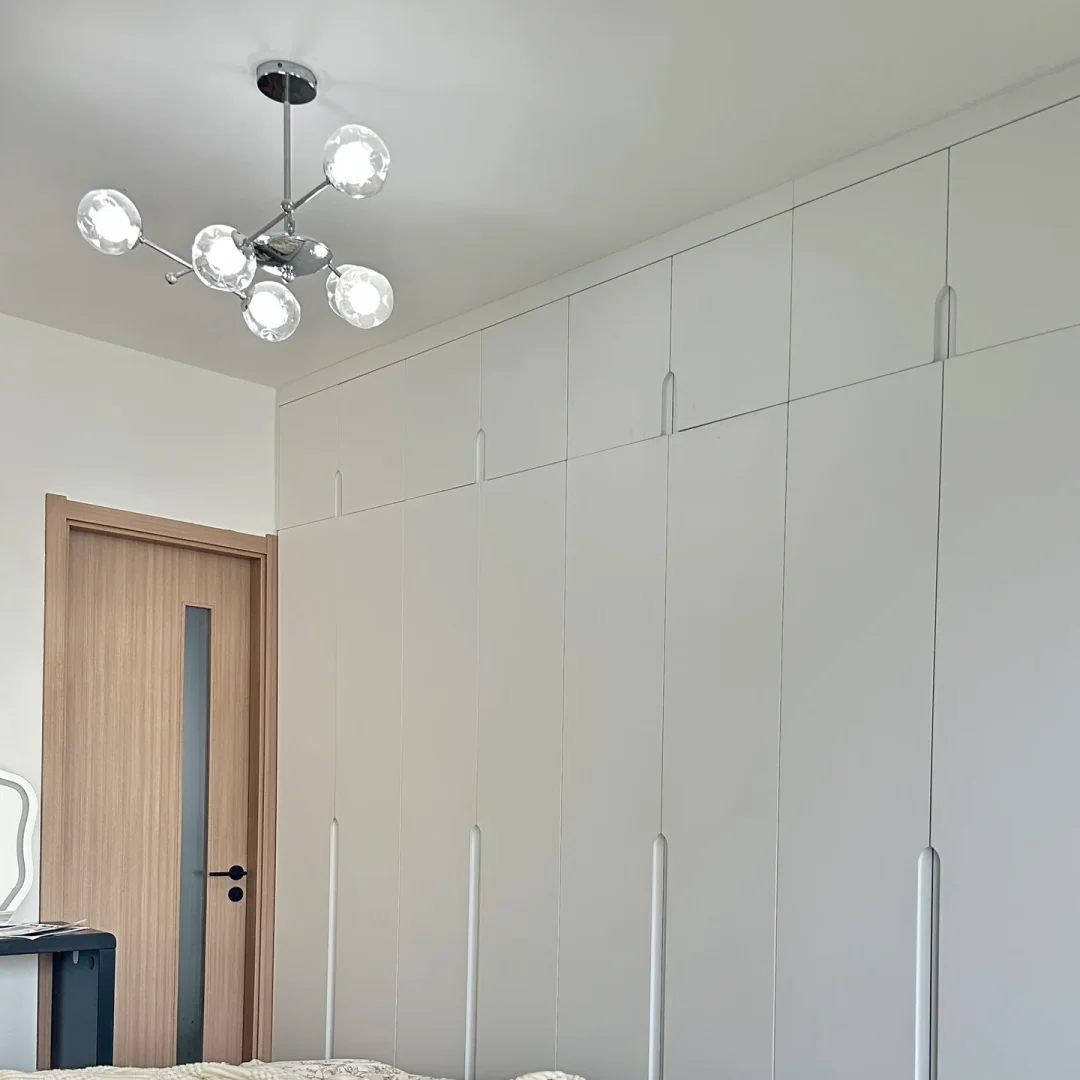 Globe chandelier with clear glass globes and chrome metal arms near doorway