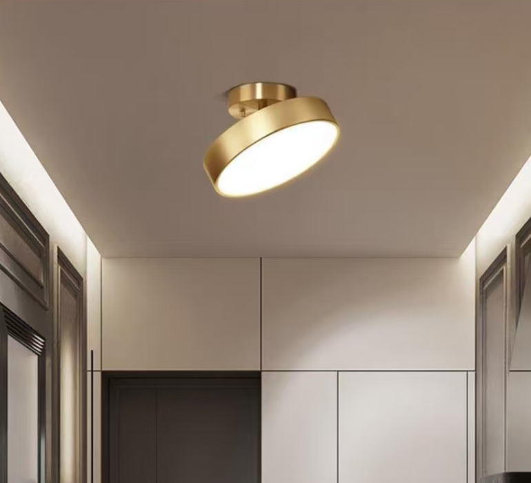 Brass drum flush mount ceiling light with angled cylindrical shade and glowing diffuser