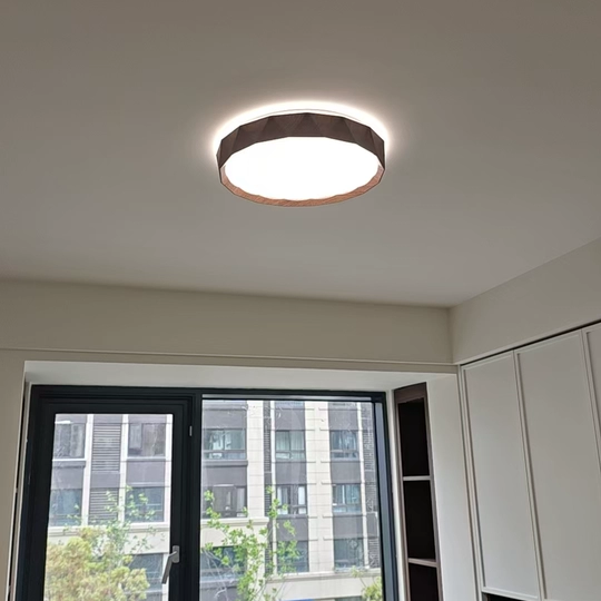 Walnut wood flush mount ceiling light with warm glowing round diffuser