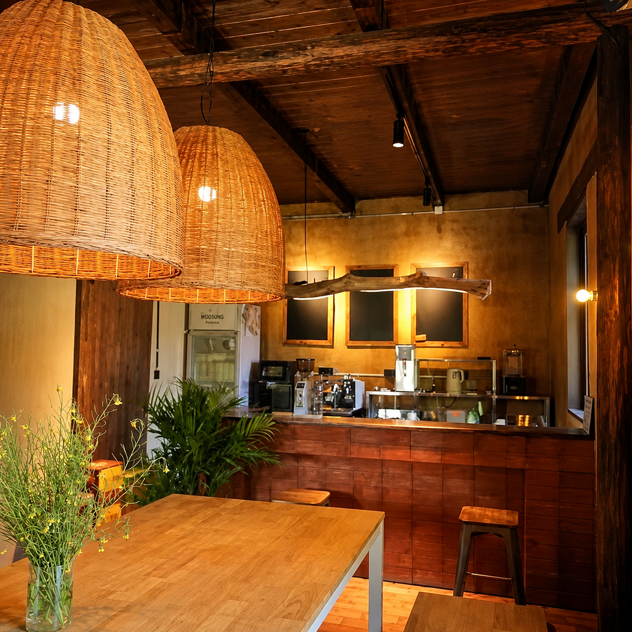 Rattan bell pendant light with woven conical shade glowing from inside