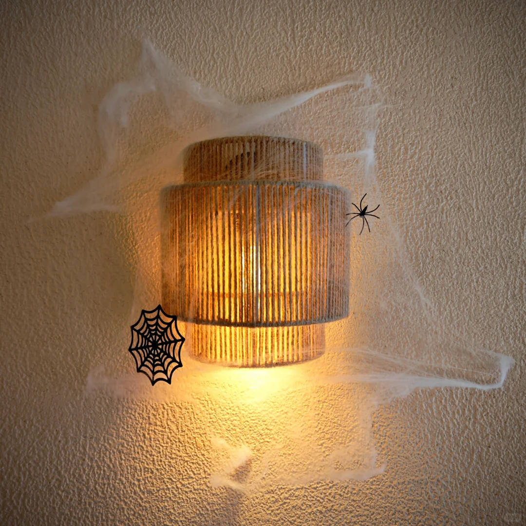 Woven rope drum wall sconce with warm amber glow and vertical woven texture