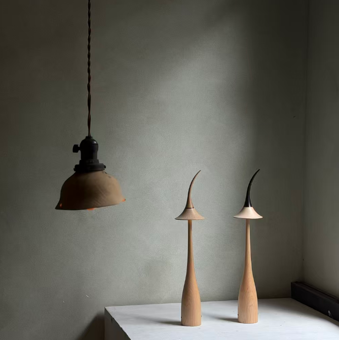 Maple wood cordless table lamp with curved shade and tall light-wood body.