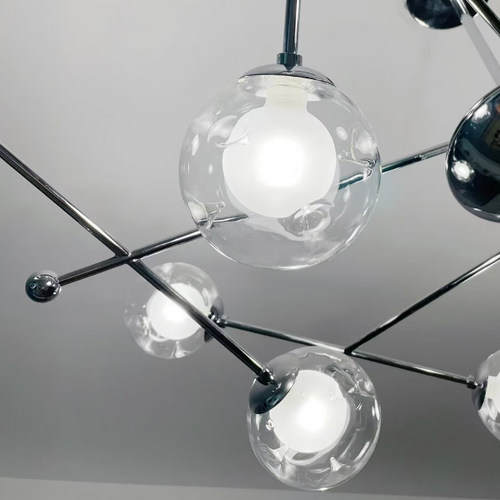 Close-up globe chandelier showing clear glass shades on chrome metal arms