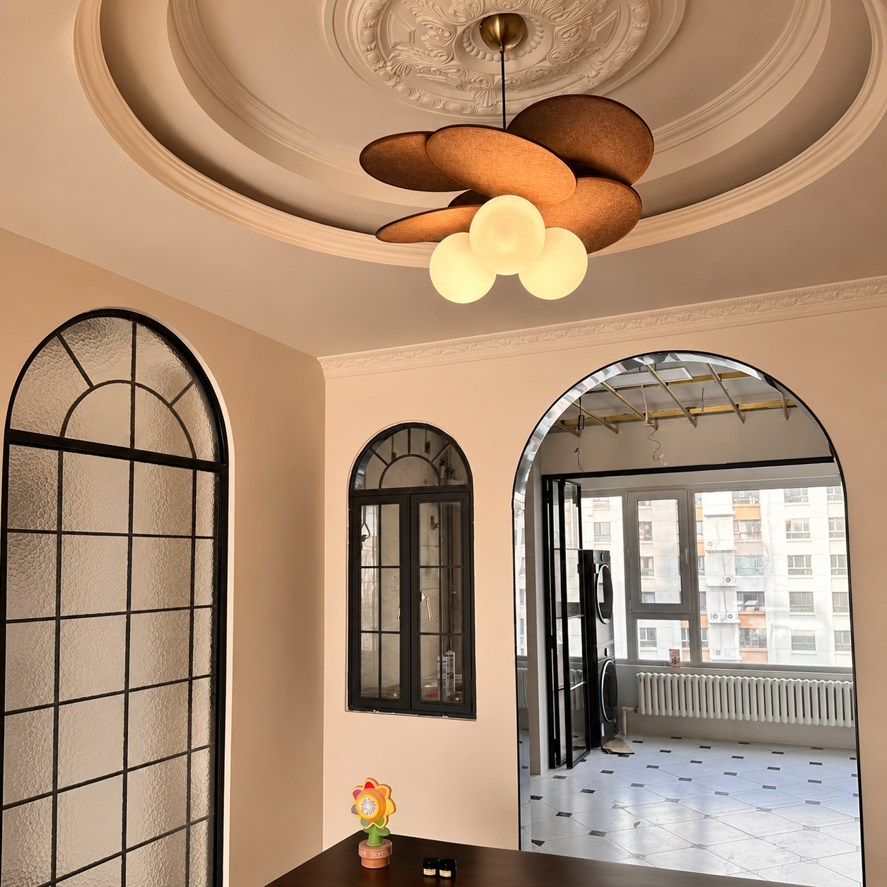 Petal pendant light with dark brown fabric petals and three glowing white globe bulbs.