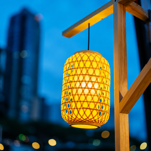 Hanging woven golden lantern with cylindrical mesh lattice shade and warm bottom glow