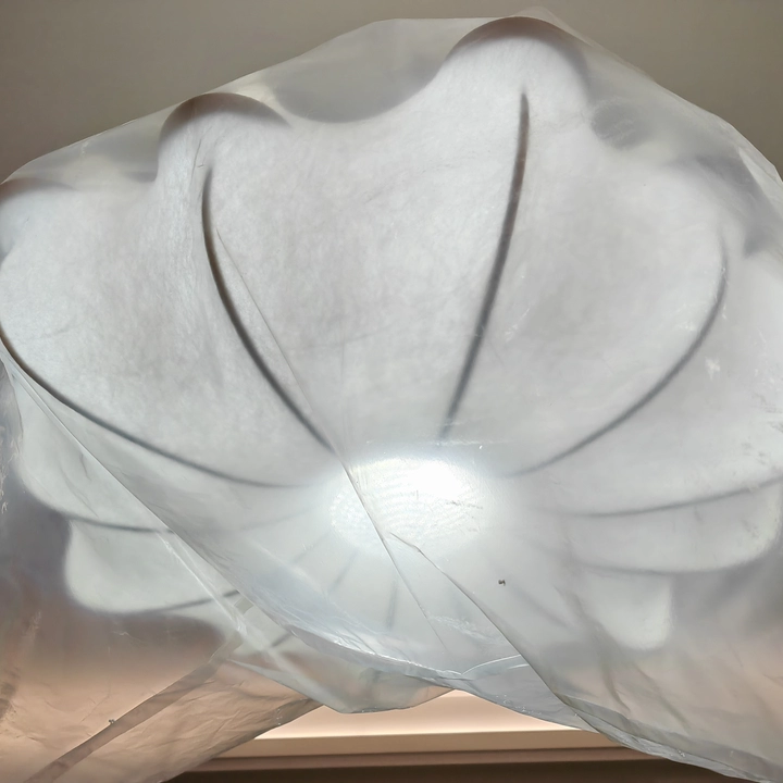 White silk petal chandelier shade close-up with curved layered fabric and central seam