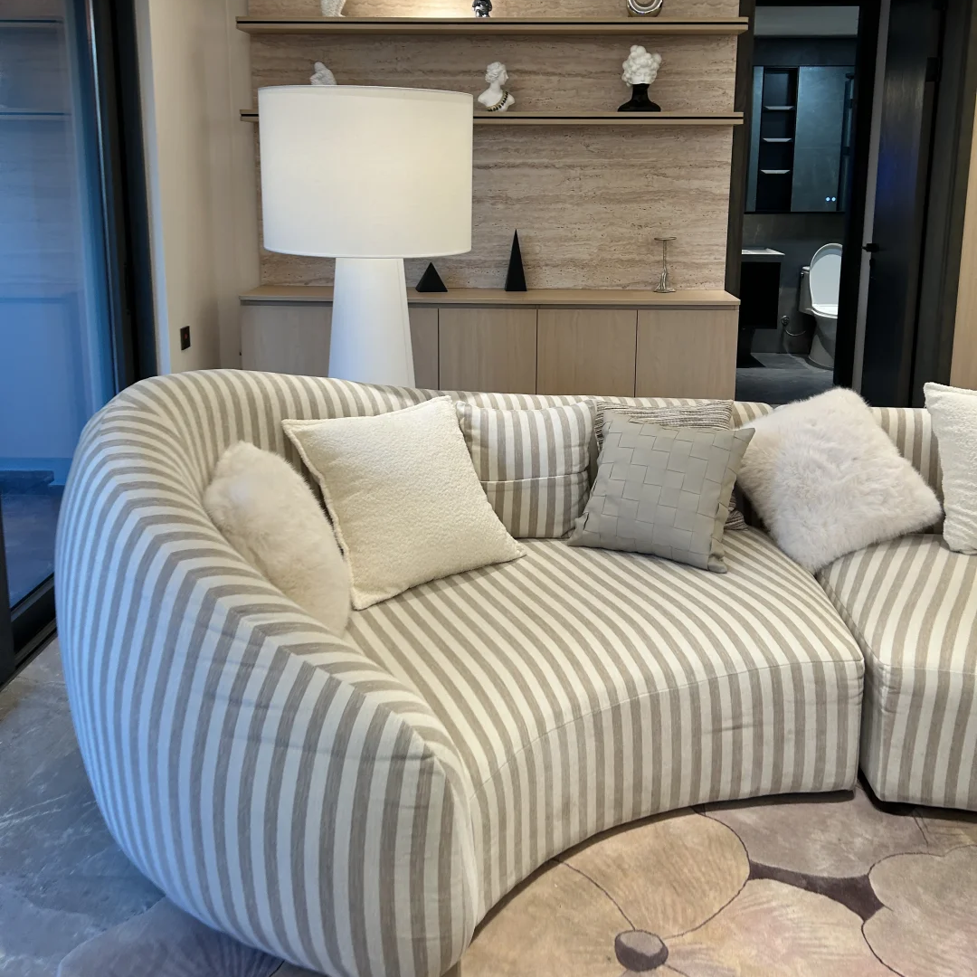 White fabric floor lamp with drum shade and curved cylindrical base