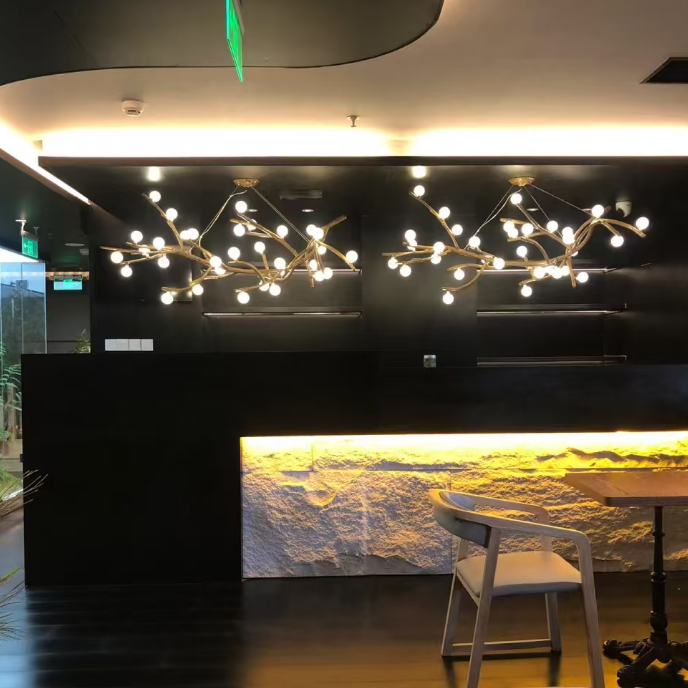 Gold branch chandelier with many round globe bulbs spread across the ceiling.