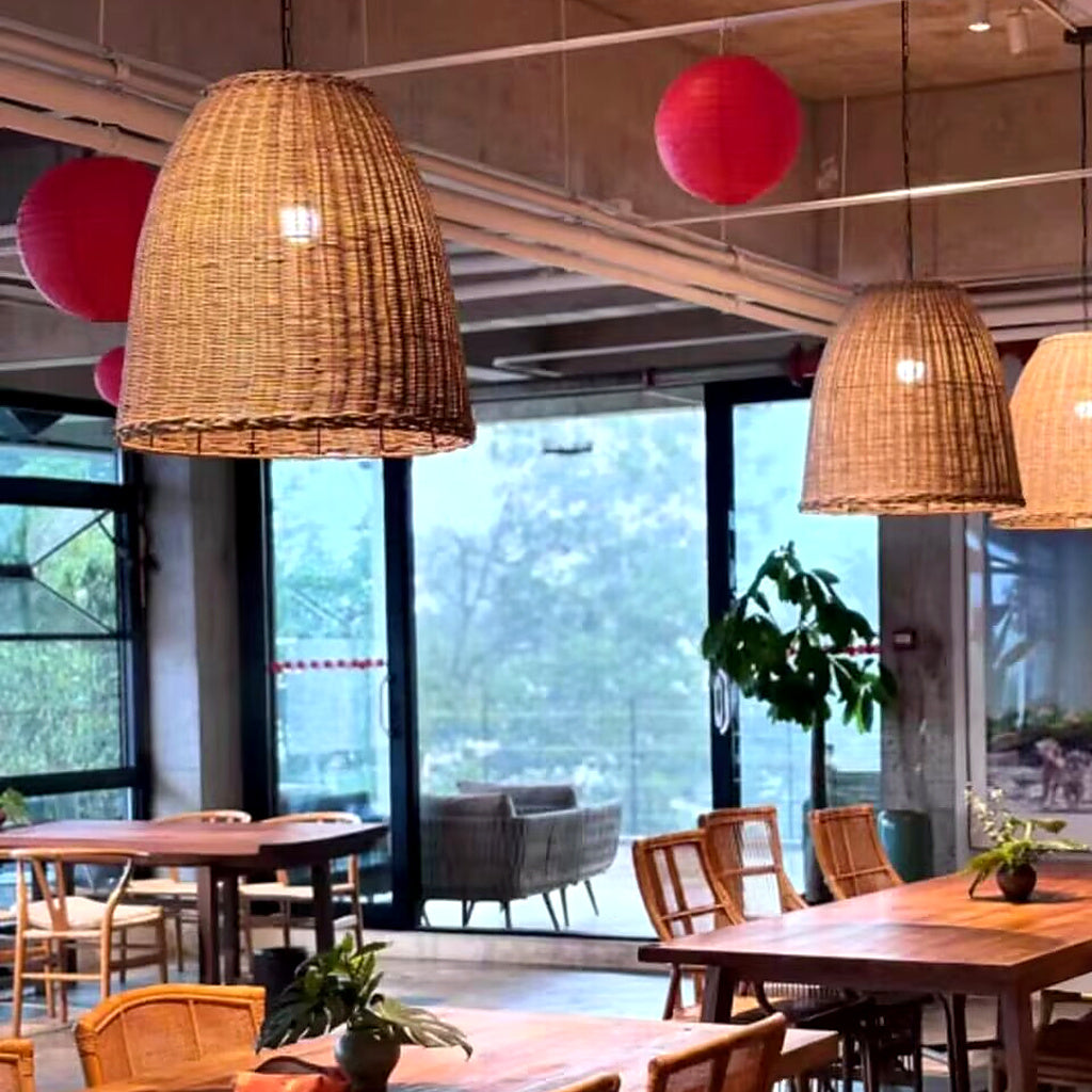 Rattan bell pendant light with woven conical shade and visible hanging cords