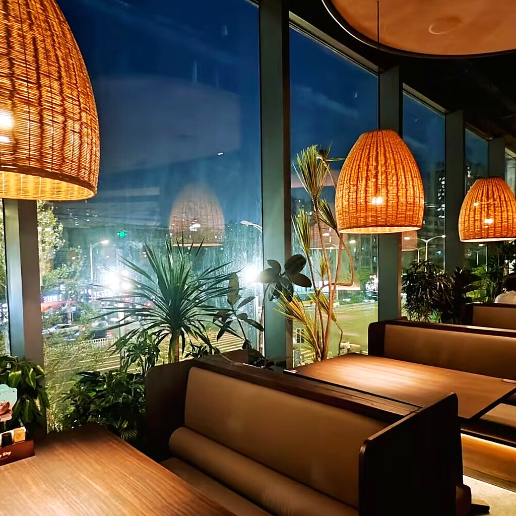 Rattan bell pendant light with woven conical shade and glowing warm bulb