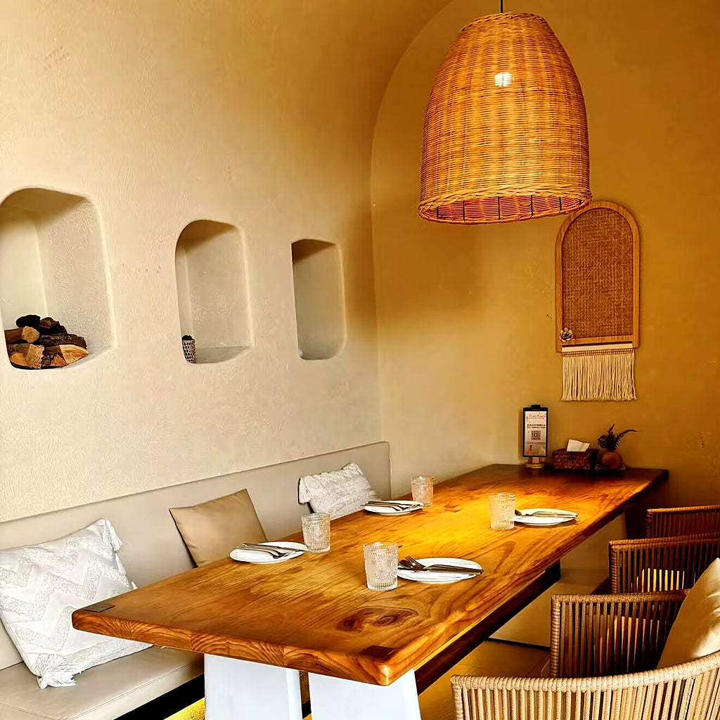 Rattan bell pendant light with woven conical shade over dining table
